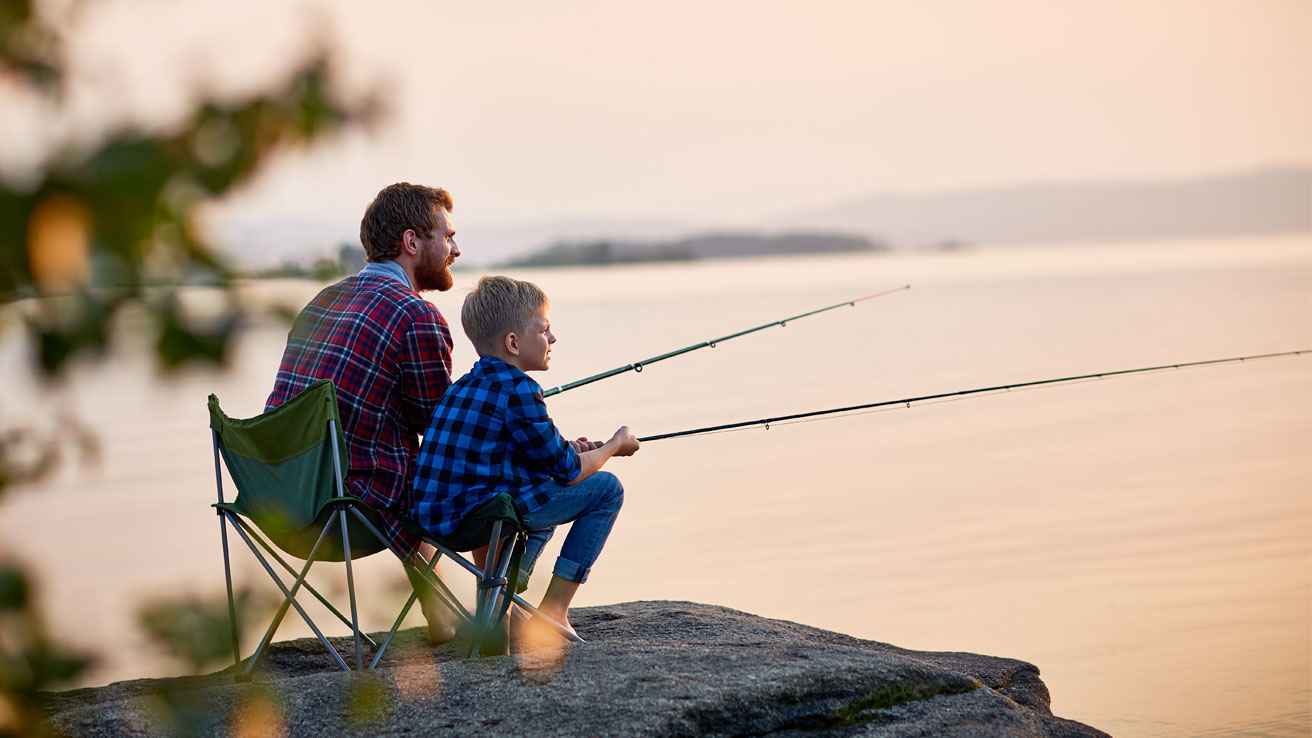 Father and son fishing at sunset