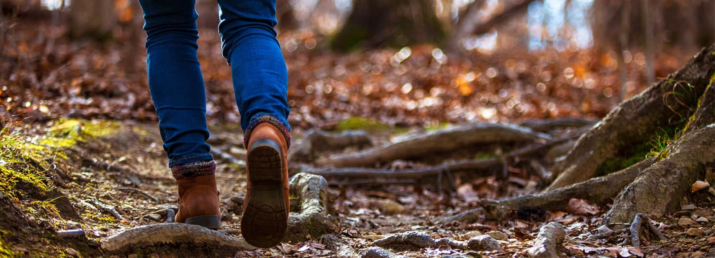 Woman walking in the woods on a hiking trail