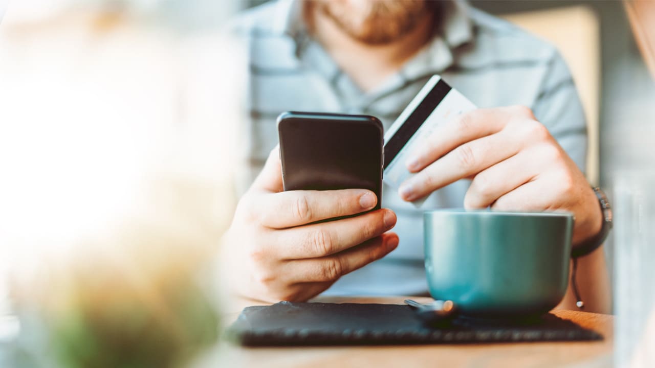 Guy using a check card at a local coffeeshop