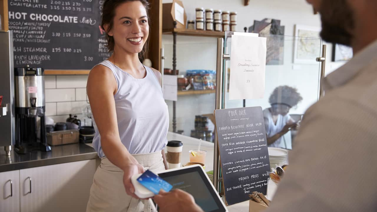 Guy using blue credit card at a coffeeshop