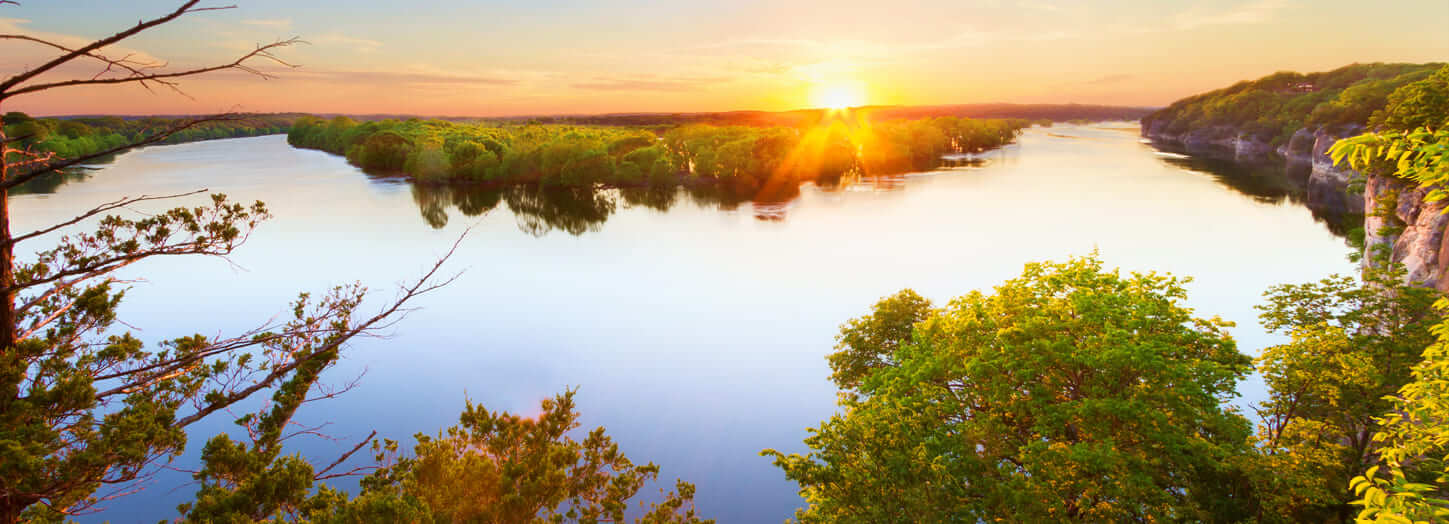 Image of a river in Arkansas. Sun is setting over the river