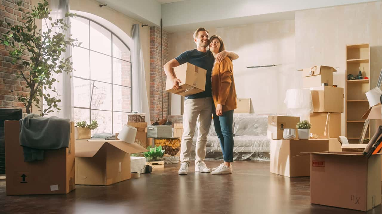 couple standing in new home smiling.